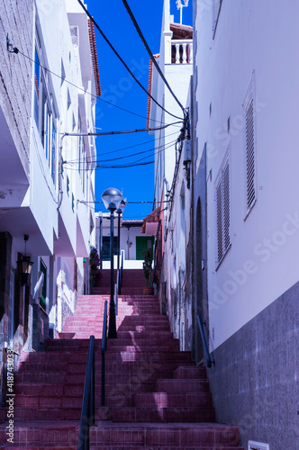 Blick auf eine nach oben führende Treppe, aus rosafarbenen Steinen mit einen Geländer in der Mitte. Rechts und  links gesäumt vom Gebäuden © lucky  photographer