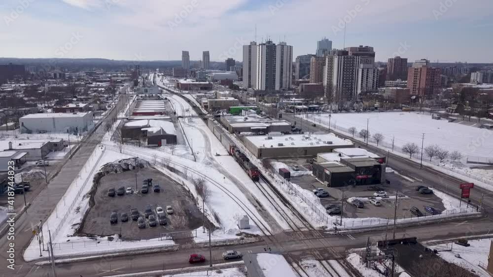 Drone shot of a train approaching a railway crossing in Winter. Drone shot of a train approaching a railway crossing in Winter.