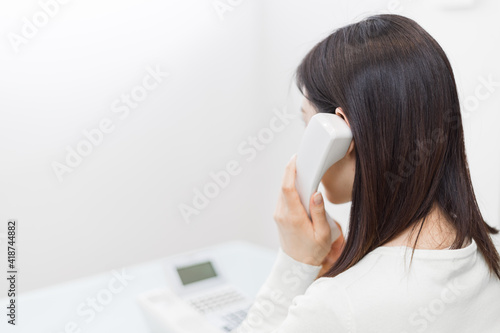 Woman talking on landline (back view)
