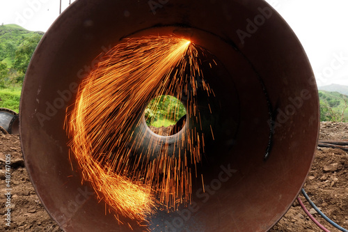 beautiful welding sparks cutting big round metal tube