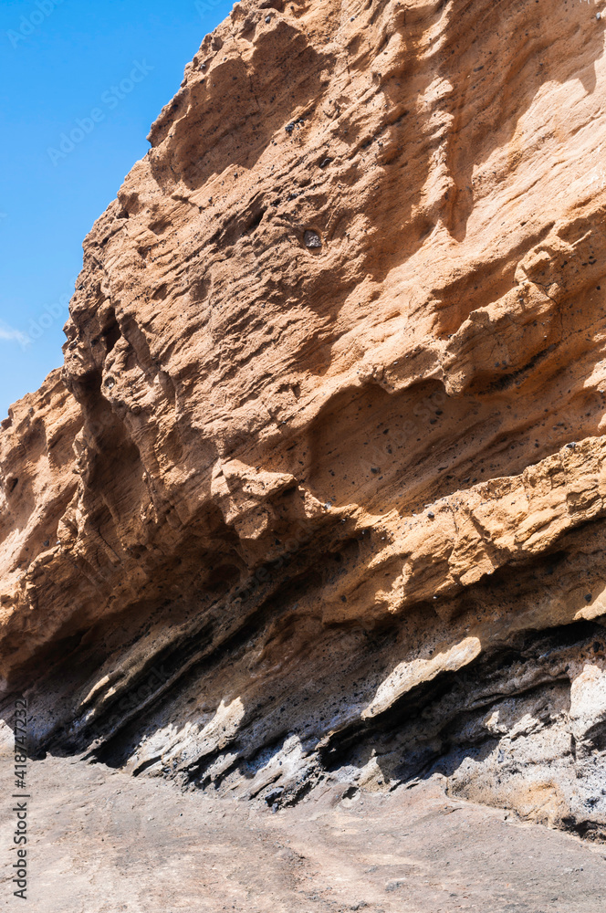 ausgewaschene Steinformation an einer Küste, es sind deutlich die verschiedenen Sedimente zu erkennen