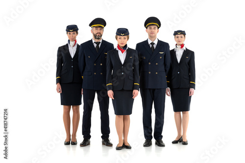 Aircrew consisting of two pilots and three flight attendants standing isolated on white background