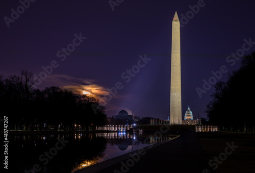 February's Snow Moon Rising Beside the Washington Monument in Washington, DC with the Nation's Capitol seen in the Background.