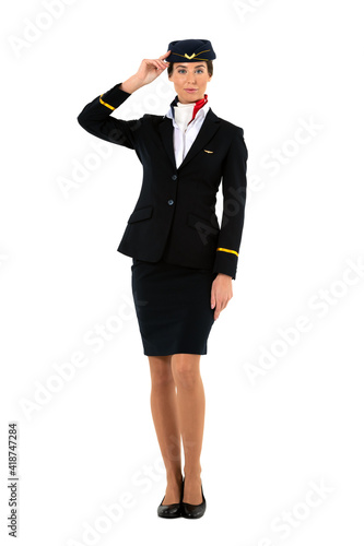 Full length portrait of a female flight attendant standing and saluting isolated on white background 