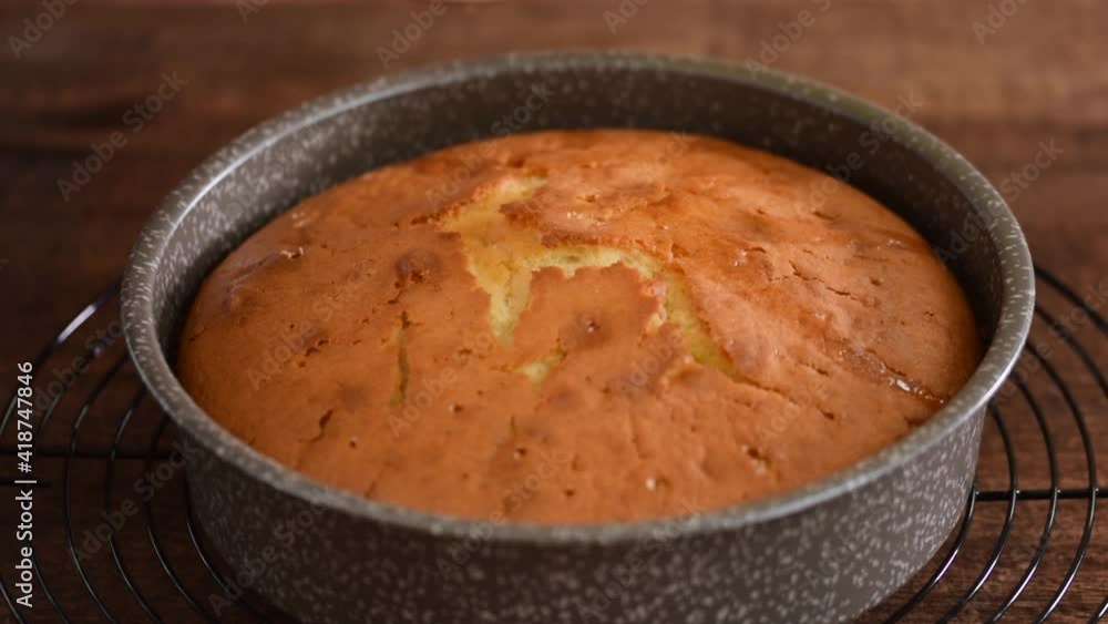 Female hands soaking a orange cake with syrup. Female hands soaking a orange cake with syrup.