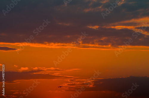 Beautiful orange sunset sky and silhouette of aircraft © E.O.