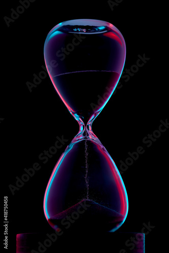 Hourglass illuminated in red and blue on a black background