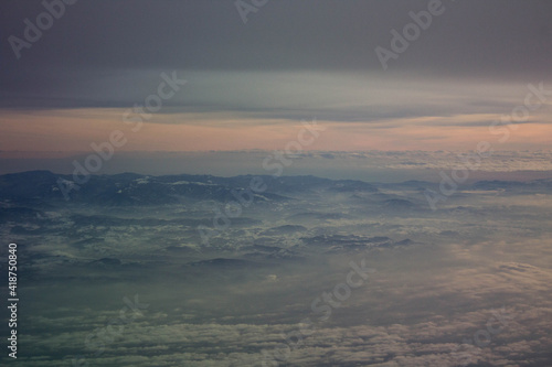 spectacular sunset seen from an airplane with clouds in the foreground and in the distance 