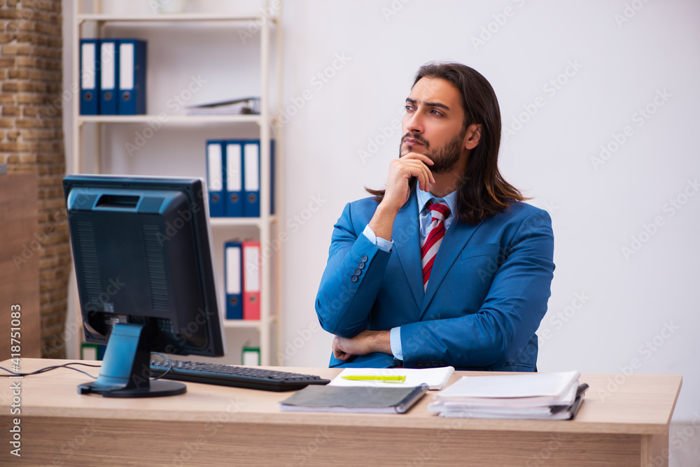 Young male employee working at workplace Young male employee working at workplace