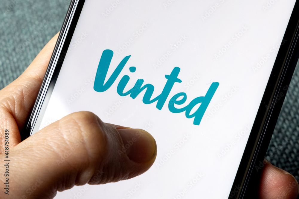 Vinted Iphone screen with vinted logo displayed with hand. Vinted is a  Lithuanian online marketplace for second hand clothing. Vinted Stock Photo