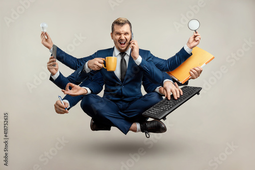 Businessman with many hands in a suit. Works simultaneously with several objects, a mug, a magnifying glass, papers, a contract, a telephone. Multitasking, efficient business worker concept.