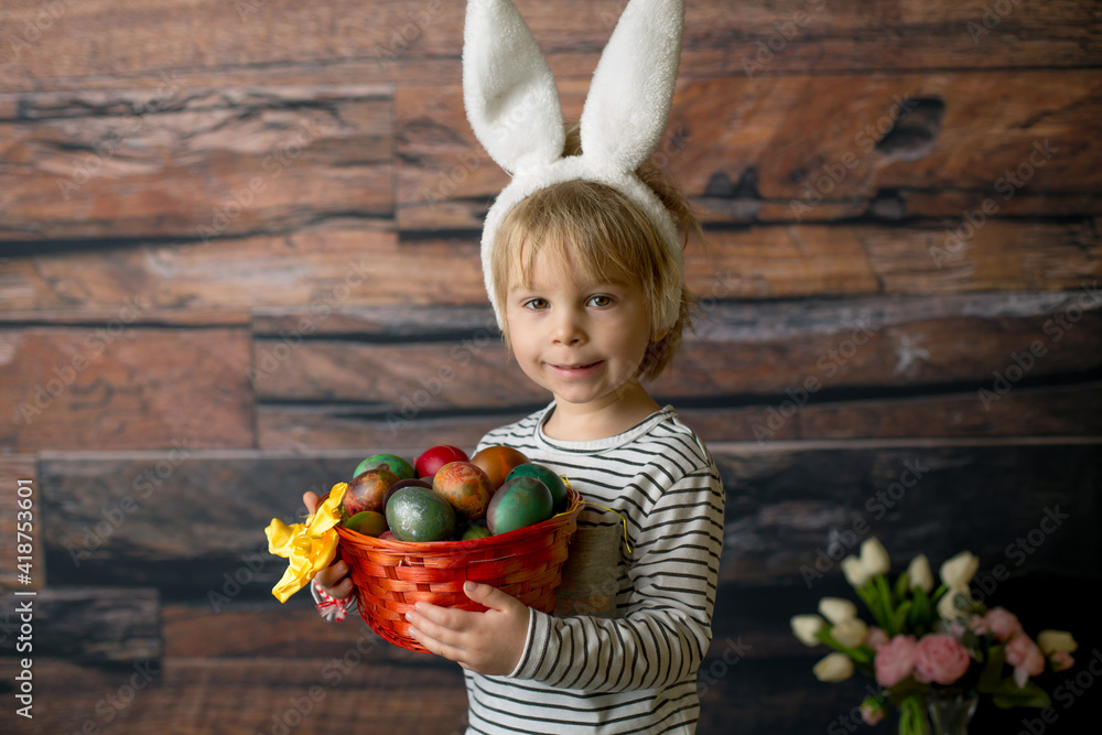 Fototapeta premium Sweet toddler child, cute boy playing with colorful easter eggs