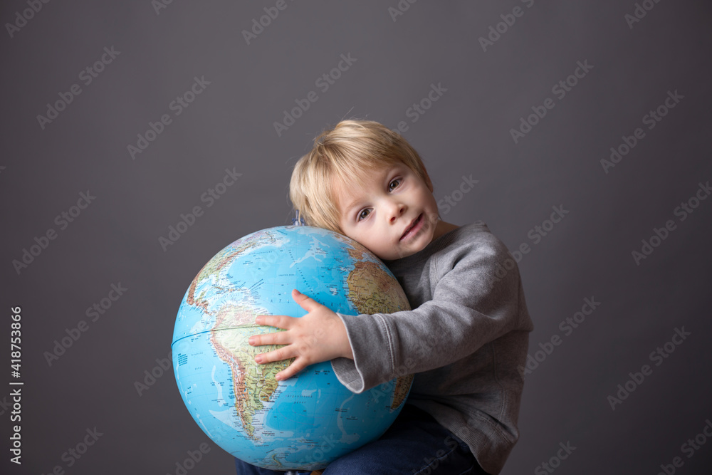 Cute toddler child, boy, hugging big globe, isolated image Cute toddler child, boy, hugging big globe, isolated image