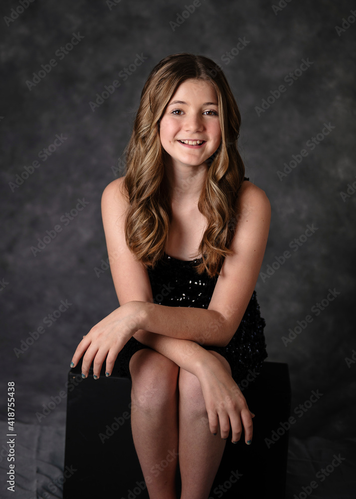 Beautiful confident tween girl with long hair in a black sparkly dress  Stock Photo | Adobe Stock