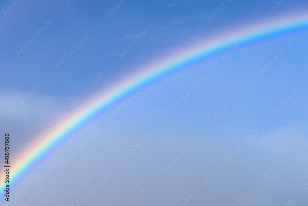 Detail of a rainbow curve on a blue sky background Detail of a rainbow curve on a blue sky background