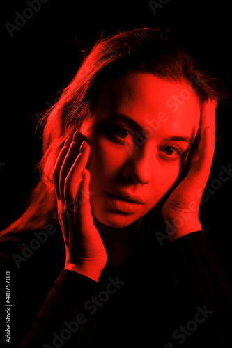 beautiful young girl in black top posing in neon red