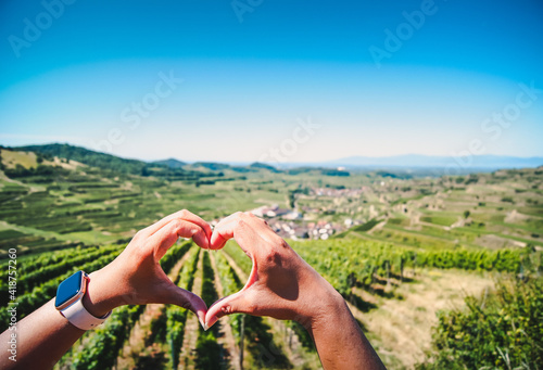 Close-up of a woman's hands forming a heart around a beautiful vineyard at Kaiserstuhl, Germany.