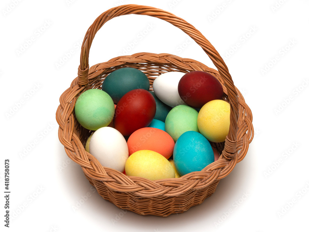Multicolored, painted boiled chicken eggs in a wicker wooden, rustic basket. Traditional elements of a happy Orthodox or Catholic Easter.