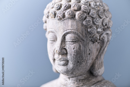 Meditating Buddha Statue on bright background. Close up. 