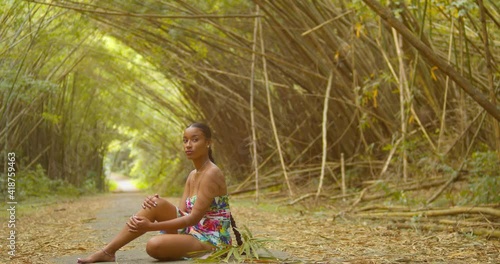 Model sits at the trail of an epic scenic bamboo cathedral on the Caribbean island of Trinidad photo