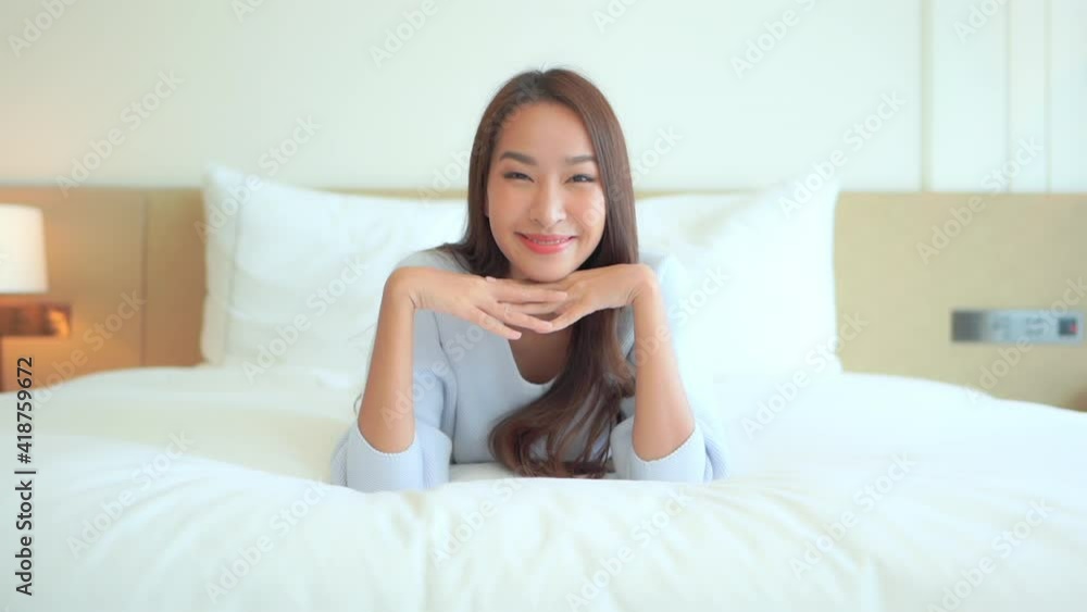 Portrait of Beautiful Asian Woman Laying on Bed Smiling to the Camera. Portrait of Beautiful Asian Woman Laying on Bed Smiling to the Camera.