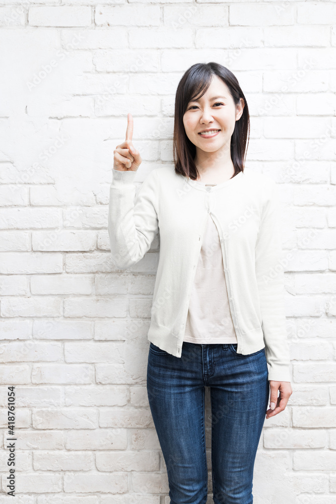 Woman standing with her index finger up (gesture) Woman standing with her index finger up (gesture)