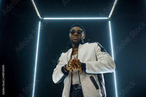 Konstfotografi Stylish rapper in sunglasses, dark background