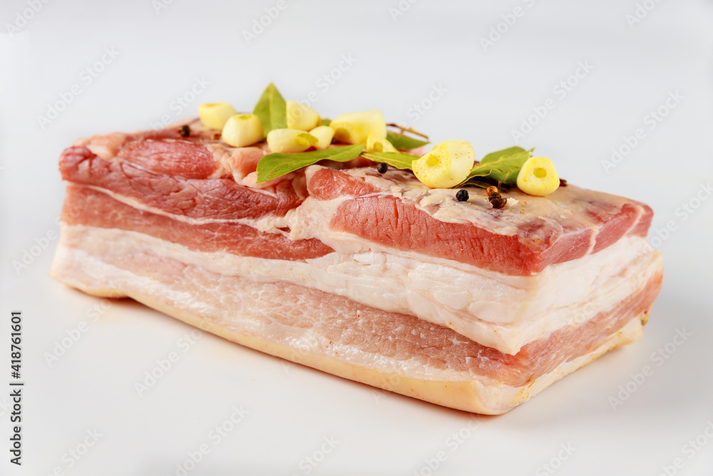 Piece of raw pork belly with garlic isolated on white background. Piece of raw pork belly with garlic isolated on white background.