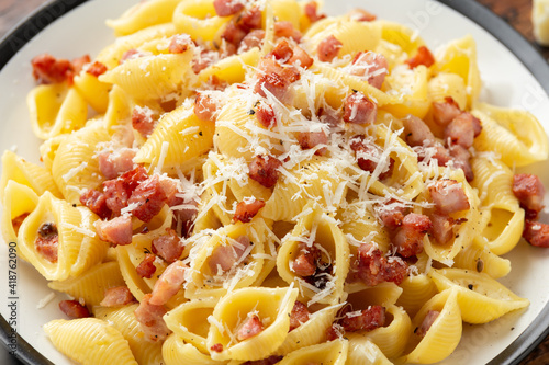 Classic Pasta carbonara with bacon, egg, cream, black pepper and Parmesan Cheese on plate. Italian food