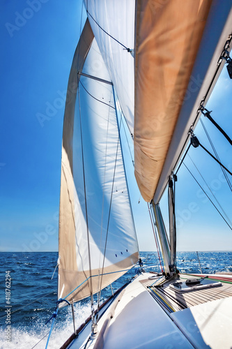 Sailing boat at open sea on a bright sunny day, vertical