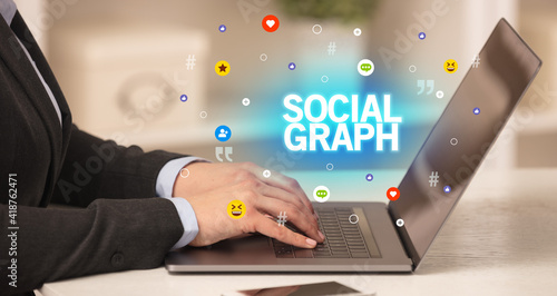 Freelance woman using laptop with SOCIAL GRAPH inscription, Social media concept