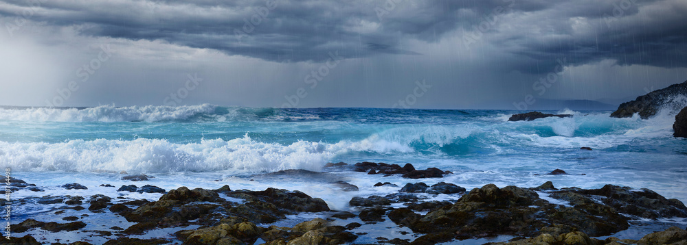 Ocean coast with dark rain thunder storm, stormy clouds and high waves sea. Dramatic seascape background.