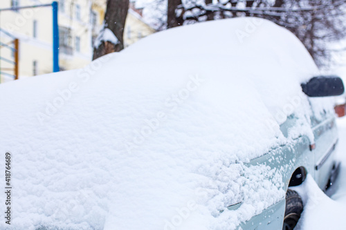 car under snow during winter snowfall in street outdoor in Russia © yurakrasil