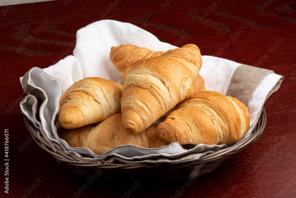 Butter croissants on a serviette in a basket to serve for breakfast Butter croissants on a serviette in a basket to serve for breakfast