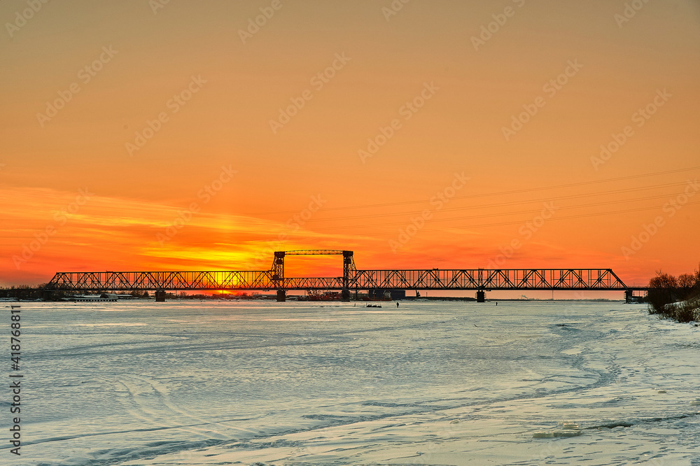 Sunset on the Severnaya Dvina river in Arkhangelsk with a bridge