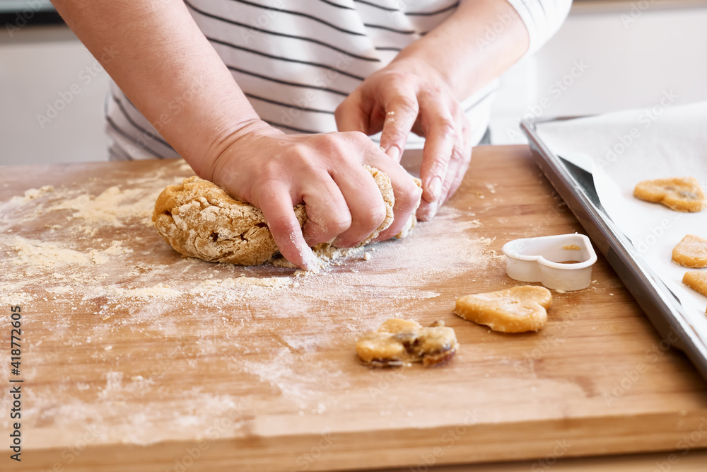 Woman kneading dough for cookies on the table in the kitchen. Gluten free flour cookies. Homemade healthy eating. Woman kneading dough for cookies on the table in the kitchen. Gluten free flour cookies. Homemade healthy eating.