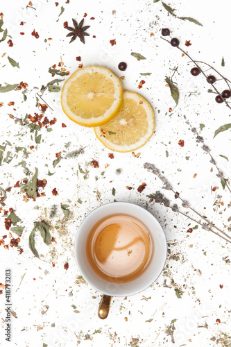 Herbal tea, top view. Dry herbs, lemon slices and tea cups on white. Herbs in bulk, zero waste and eco-friendly lifestyle, herbal medicine concept. 