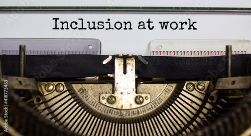 Inclusion at work and belonging symbol. Concept words 'inclusion at work' typed on retro typewriter. Business, inclusion at work and belonging concept. Beautiful background.