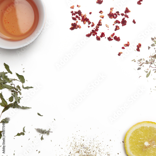 Herbal tea, top view with copy spce. Dry herbs, lemon slices and tea cups on white. Herbs in bulk, zero waste and eco-friendly lifestyle, herbal medicine concept. 