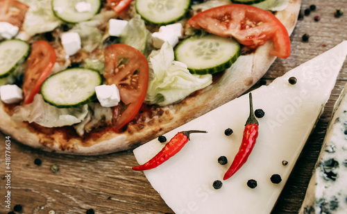 Vegetable pizza with mozzarella, fresh tomatoes and cucumber. Two types of blue cheese