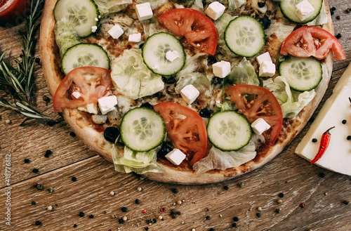 Vegetable pizza with mozzarella, fresh tomatoes and cucumber