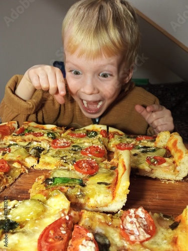 the child was delighted with the pizza with tomatoes basil spinach sesame seeds