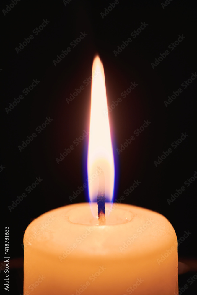 One candle flame in night dark. Close up view with copy space One candle flame in night dark. Close up view with copy space