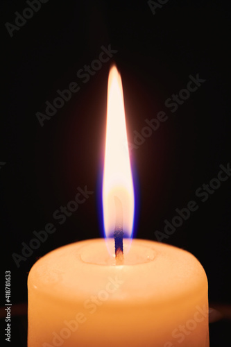 One candle flame in night dark. Close up view with copy space