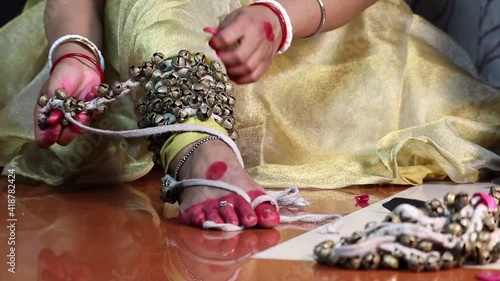 Classical Indian Girl Kathak Dancer In Traditional Dress Or Costume Tie Ghungroo Ghungru Or Noopura Which Is A Musical Anklet To The Feet Painted With Red Dye Altha Alah Mahavar Or Alta photo