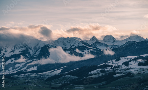swiss mountains during sunset with fog and clouds and snowy mountains in the alps © stalmphotos