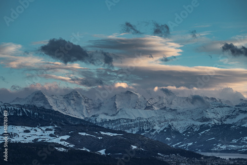 swiss mountains during sunset with fog and clouds and snowy mountains in the alps