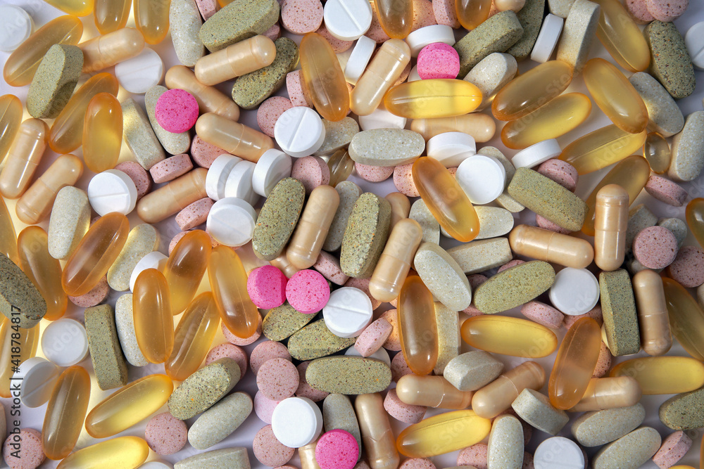 A lot of colorful medical pills, tablets and capsules from above; color photo.