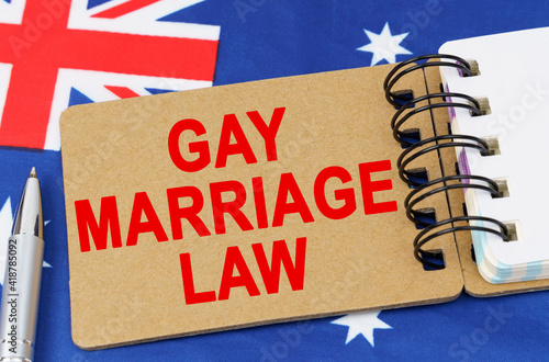 Against the background of the flag of Australia lies a notebook with the inscription - GAY MARRIAGE LAW