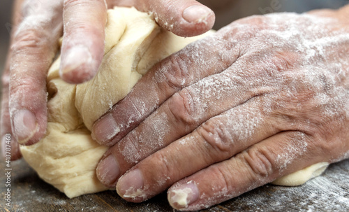 a man kneads dough with his hands on the table